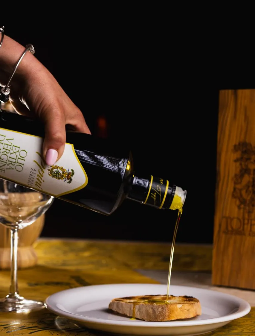 Olio Toppini versato su una bruschetta