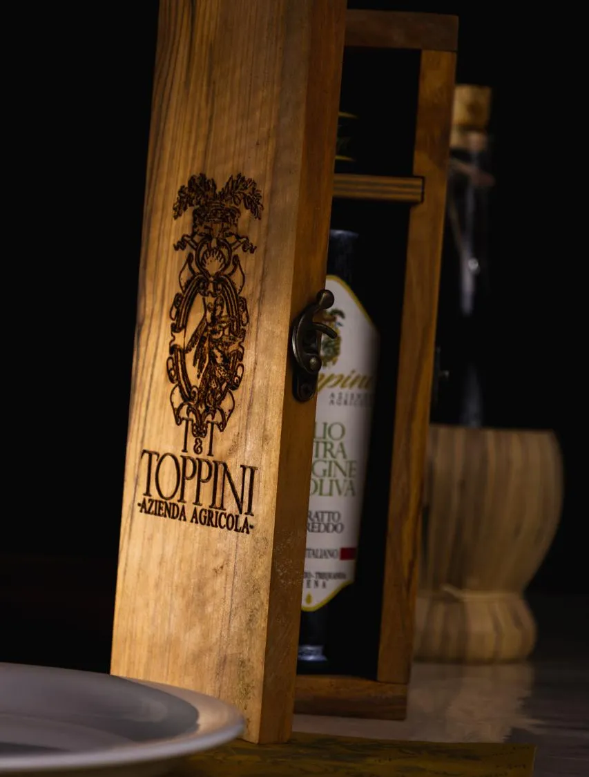 La cassetta di legno con la bottiglia di olio Toppini