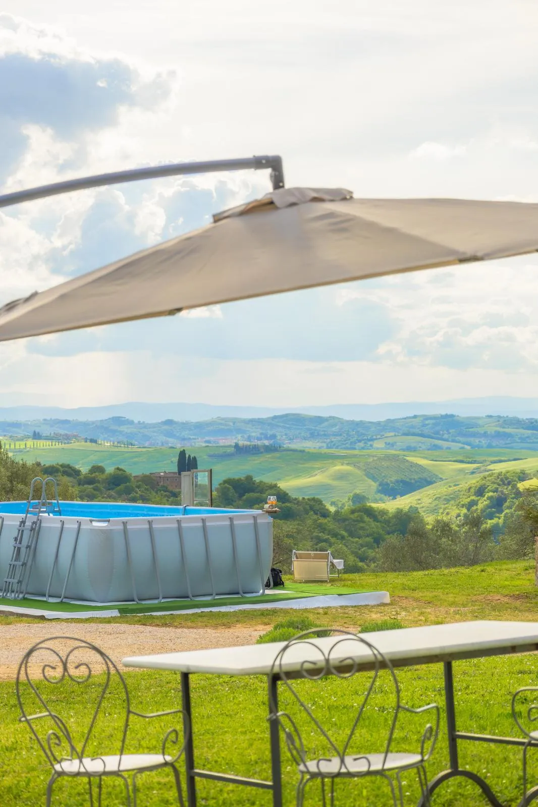 La piscina di Pascianella con l'ombrellone e la vista sulle colline delle Crete Senesi
